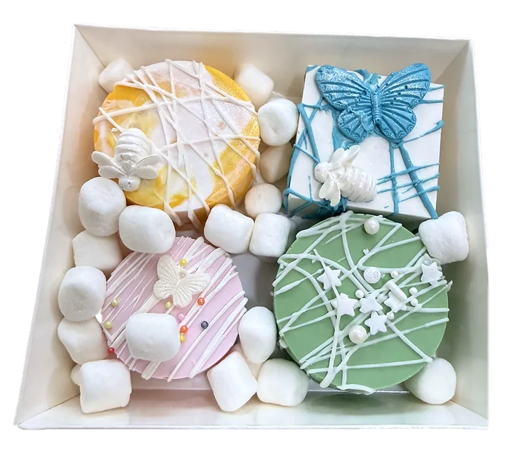 Gift box of pastel bonbons with a blue butterfly and bumblebees, nestled in marshmallows
