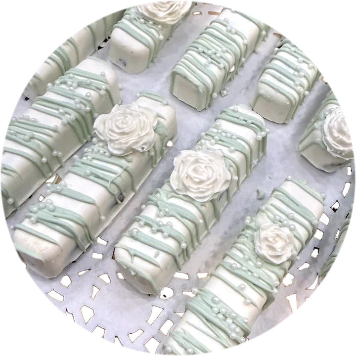Close-up of white chocolate bars with sage drizzle, pearls and sculpted roses